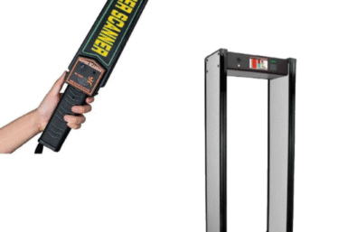 Security personnel using a walk-through metal detector at a public building entrance to prevent theft and violence in a crowded space.